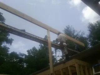 Carpenter setting a ridge beam over a new addition frame — Ice Dam Removal by Roofing Brothers in Berne