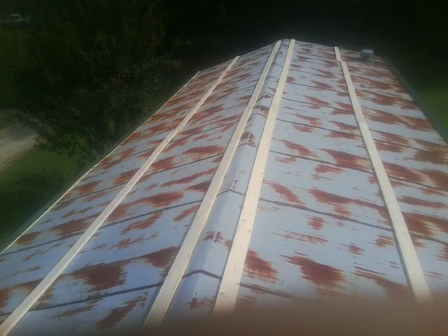 Rusted metal roof panels with new wood purlins before replacement — Storm Damage Roof Repair in Berne by Roofing Brothers