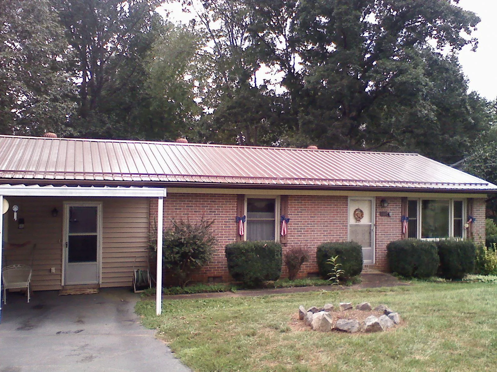 Bronze metal roof and carport on a brick ranch home — Roof Repair work by our crew in Berne